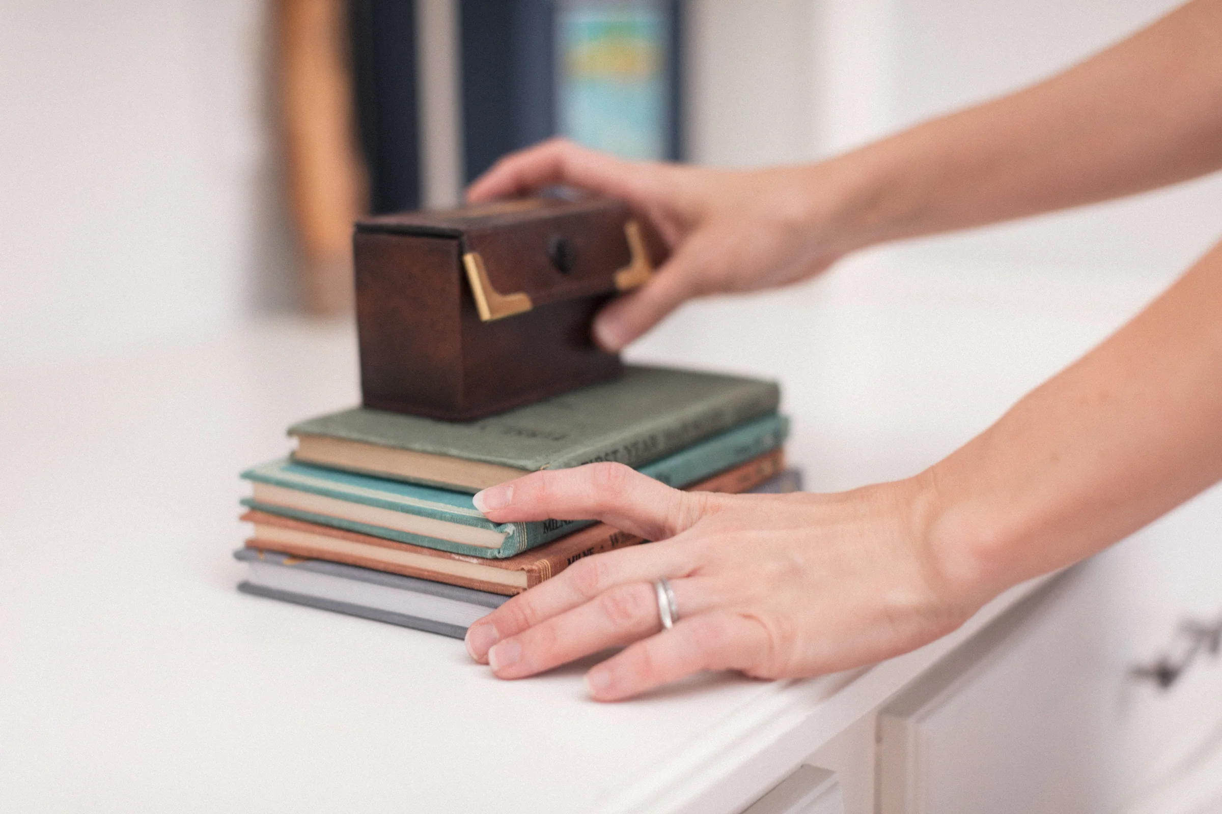 Hands arranging books on a shelf