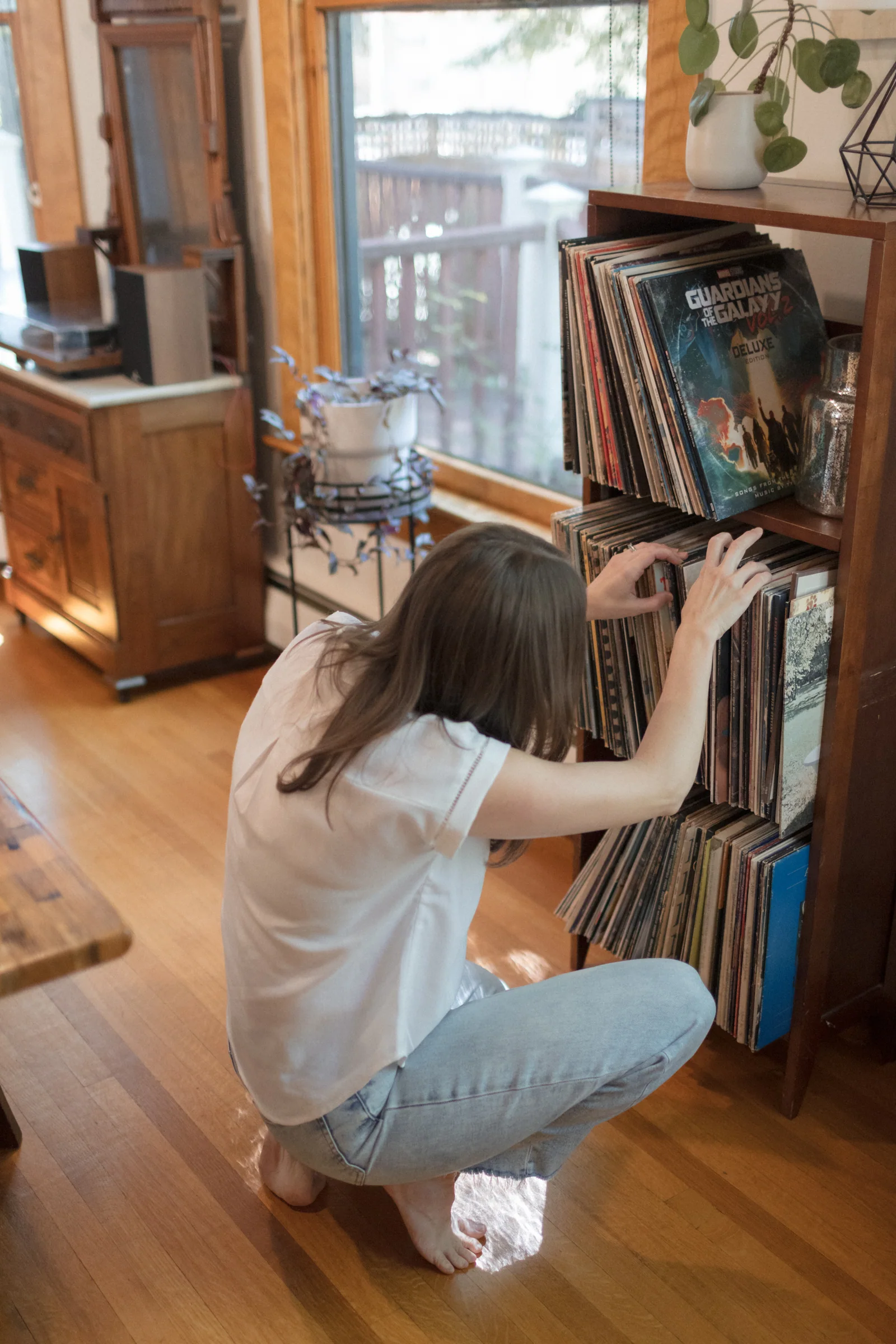 Cally kneeling beside a record collection while organizing it