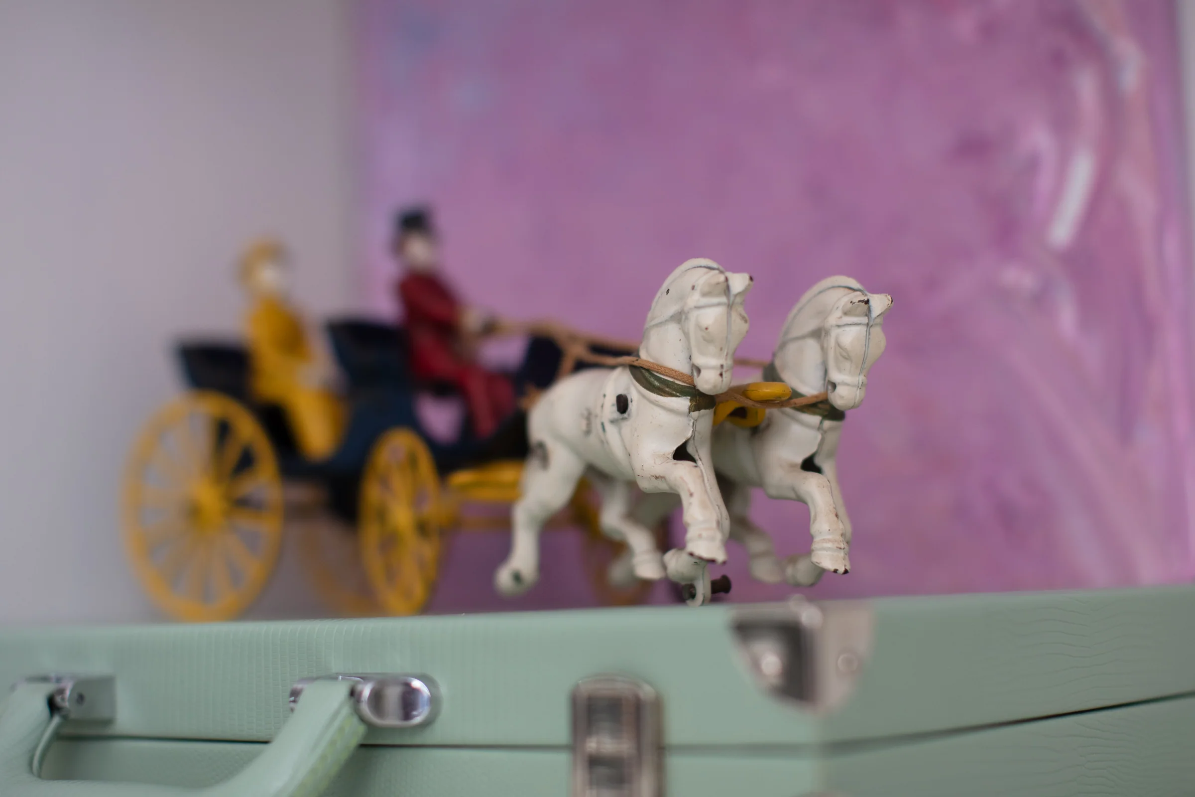 Small metal horses and a carriage displayed on a shelf